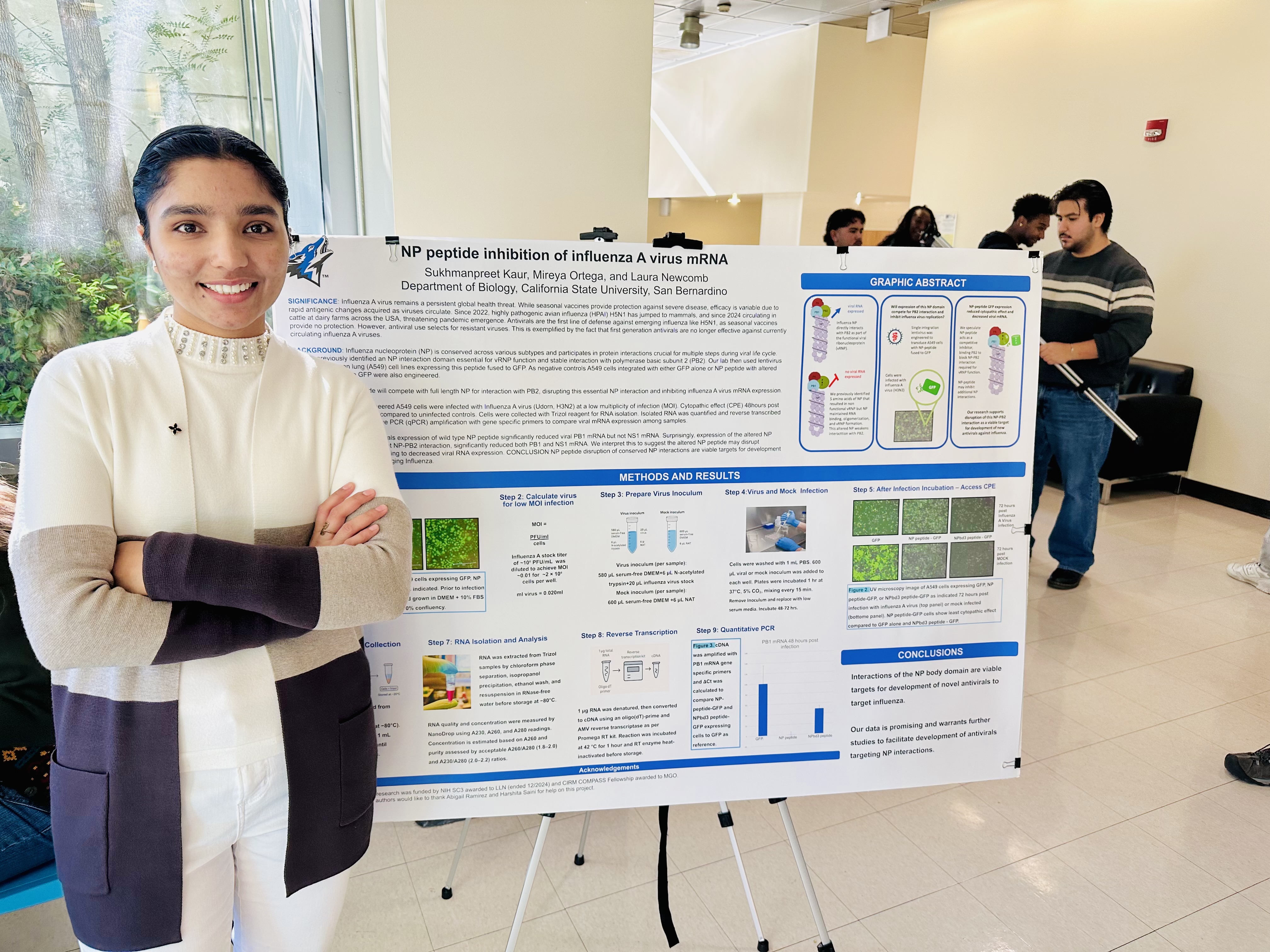 Sukhmanpreet Kaur standing beside her influenza A virus research poster at CSUSB